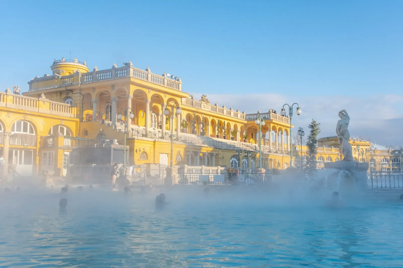 Morgonånga vid den gula fasaden på Széchenyibadet