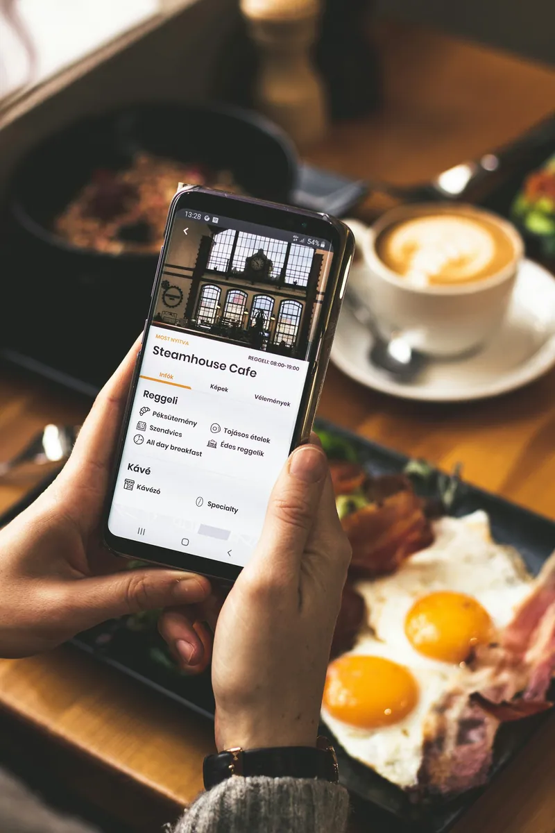 En besökare läser en kafémeny på mobilen