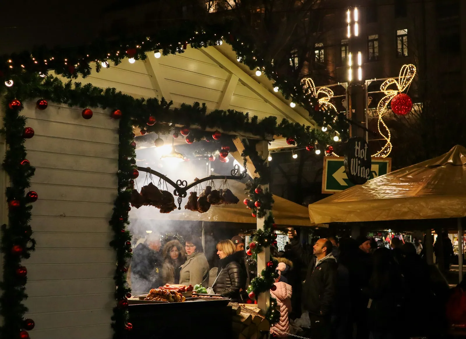 Julbelysning och besökare vid ett stämningsfullt kvällsställe i Budapest
