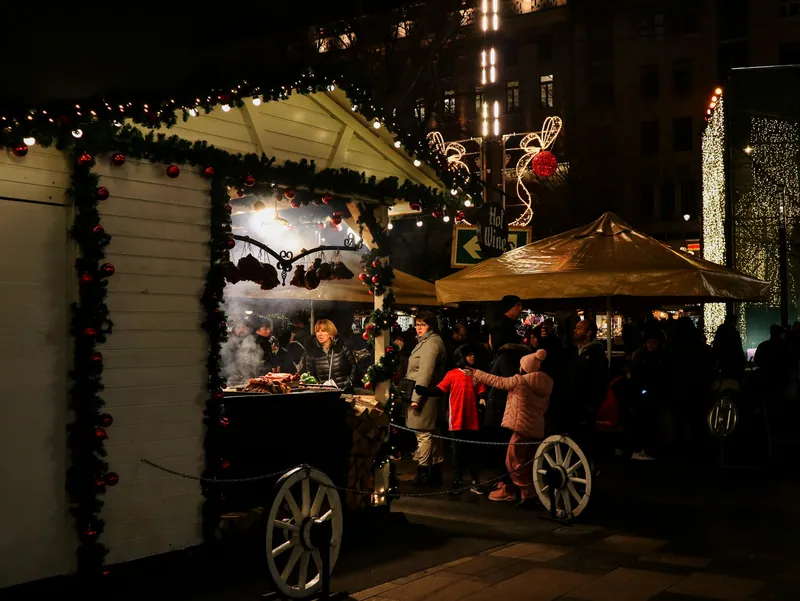 Människor och juldekorationer på ett kvällsställe i Budapest
