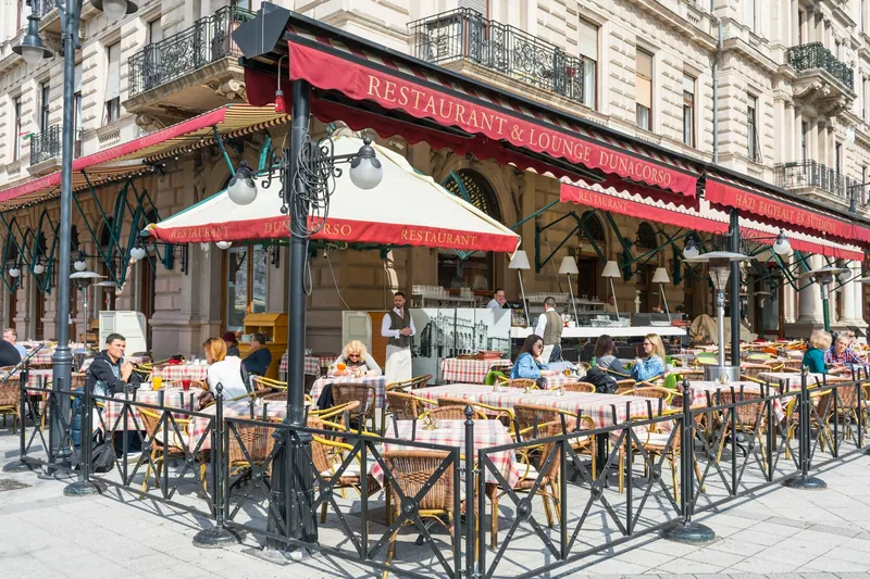Uteservering med bord och parasoller i Budapest
