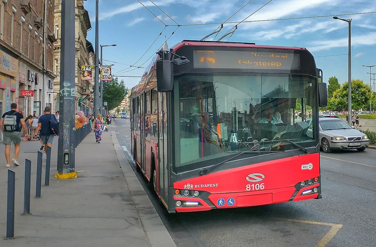 Röd trådbuss vid en hållplats i Budapest.
