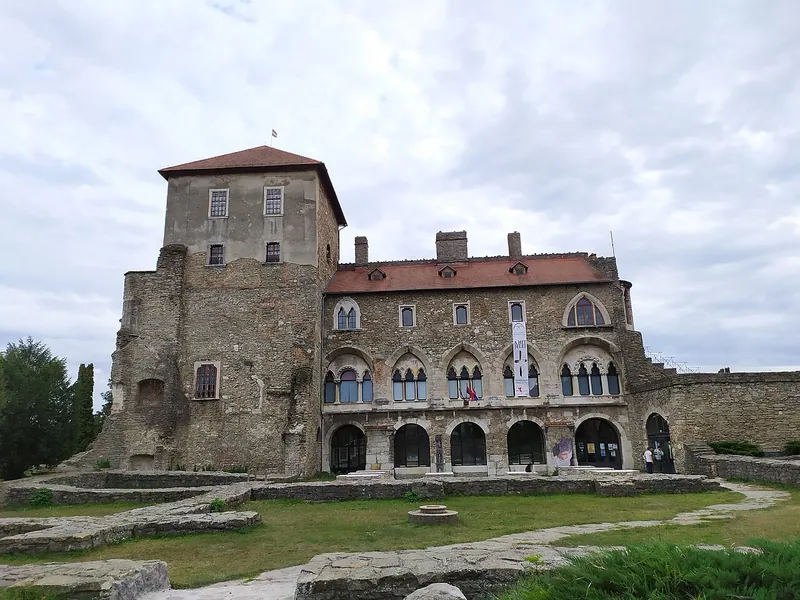 Tata slott med stenmur och innergård.
